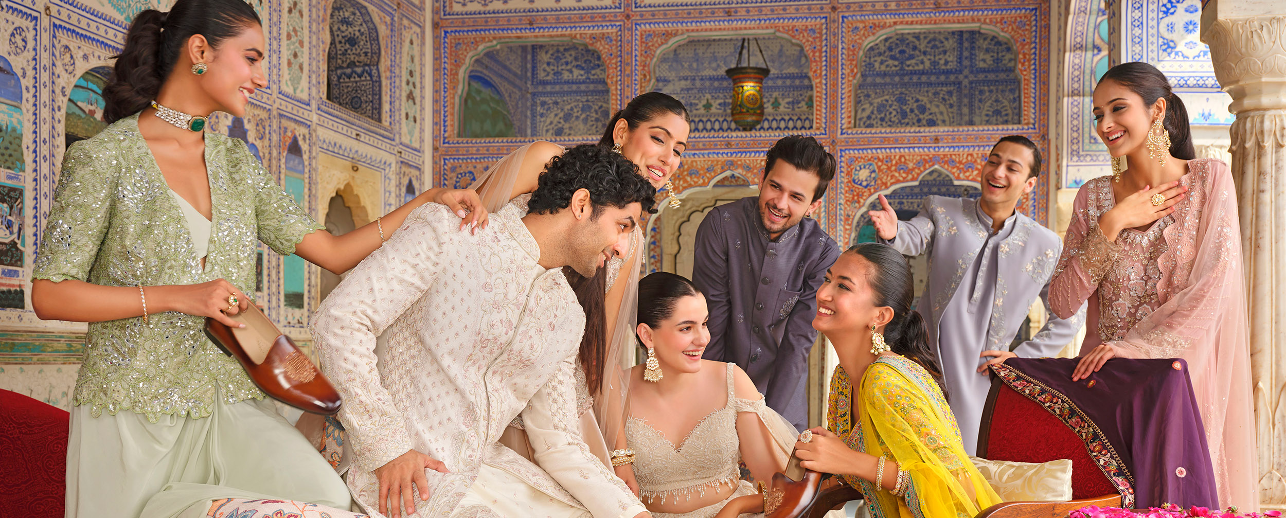 A group of people wearing stylish lehengas and kurtas at a festive wedding celebration.&nbsp;